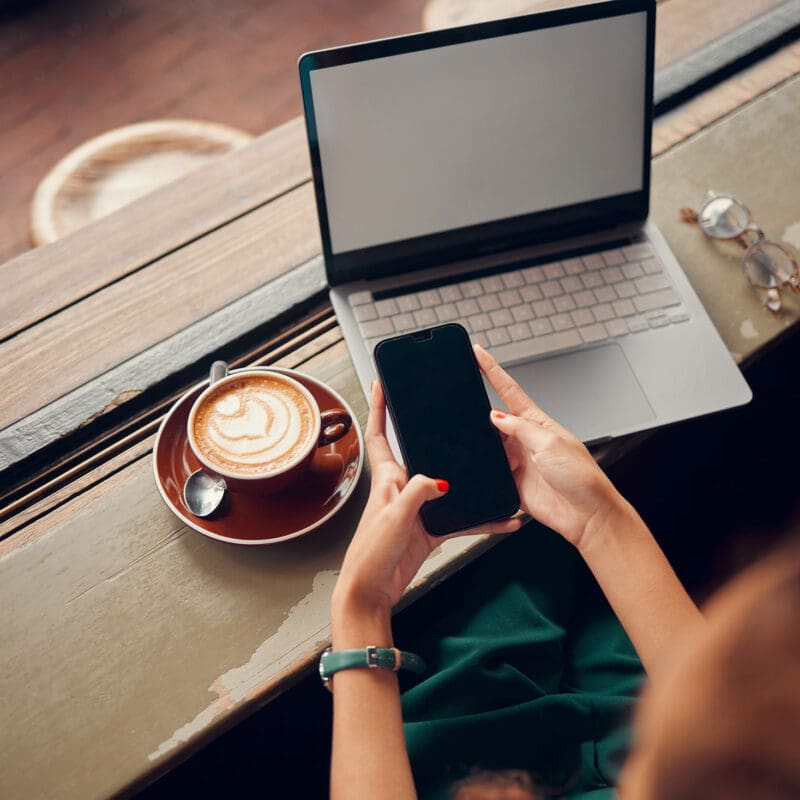Coffee and a laptop and phone screen