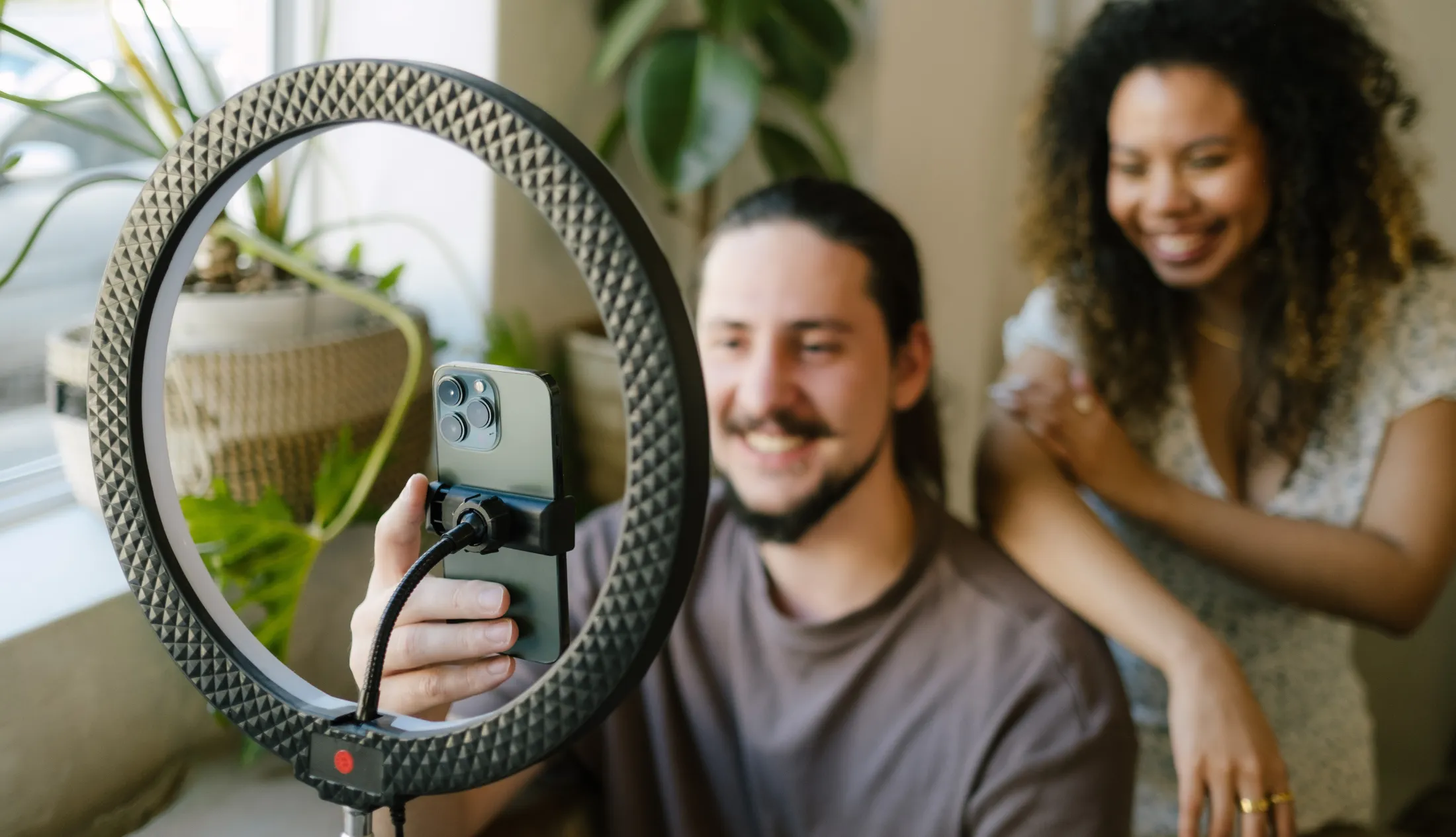 Inhouse Designer, Talana, and Jnr Social Media Managaer, Jacques, taking vidoes on an iphone for reels and tiktoks doing trends for social media