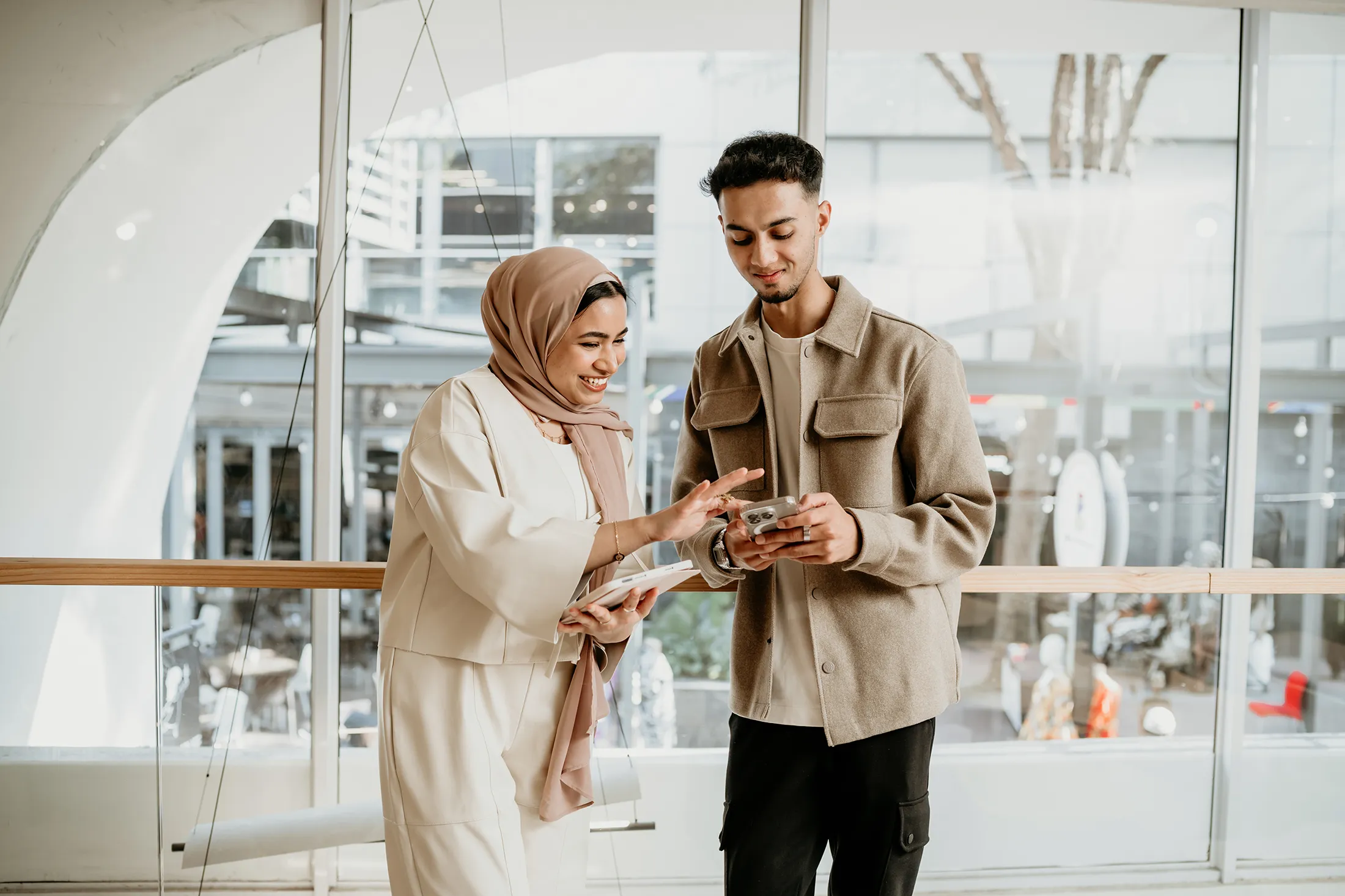 Two professionals reviewing mobile content together as part of logistics website development planning