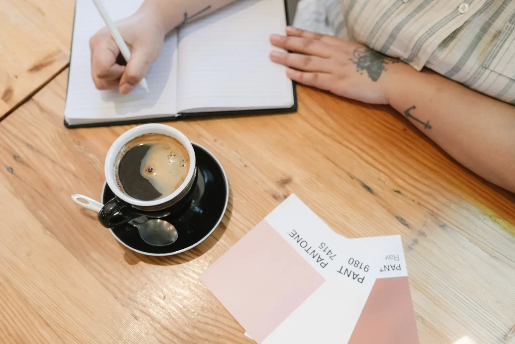 Creative professional planning ai-driven content strategies for emerging social media platforms in the evolving digital landscape, with coffee and design swatches.