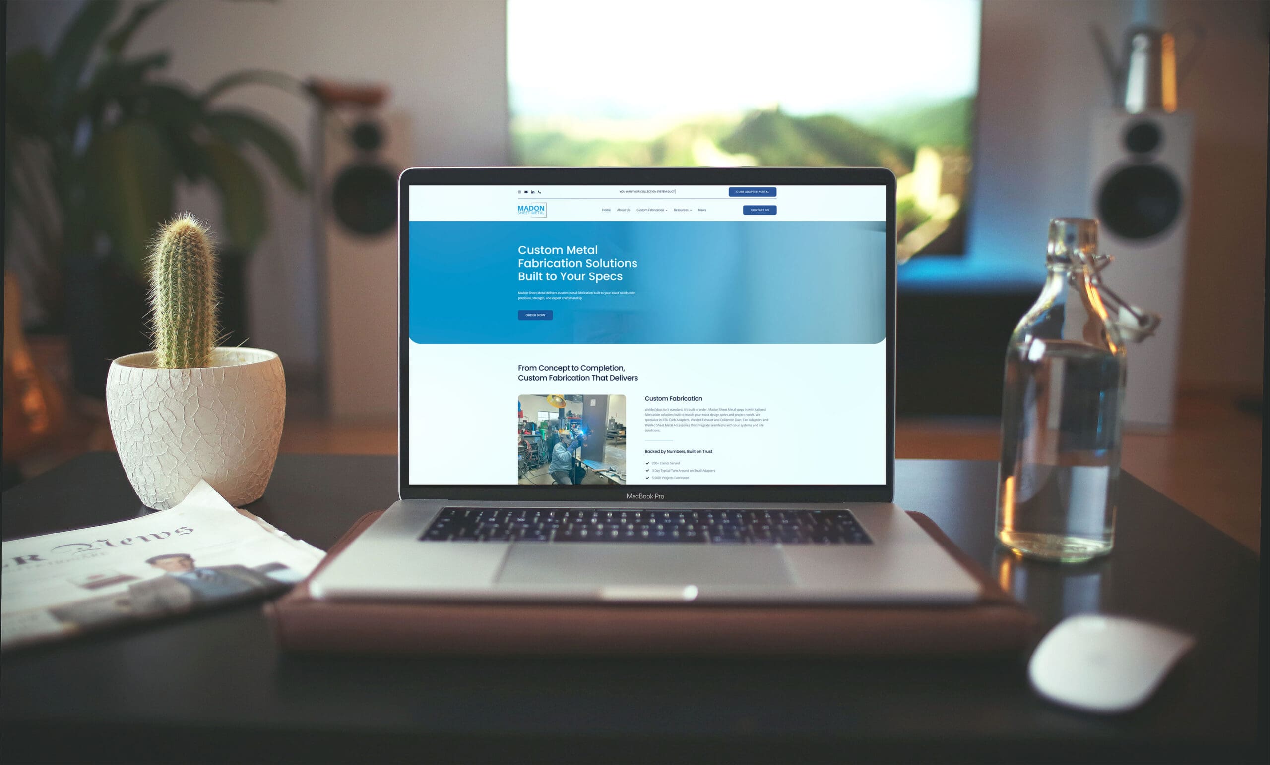 Laptop displaying the redesigned Madon Sheet Metal website showcasing custom metal fabrication services and modern layout