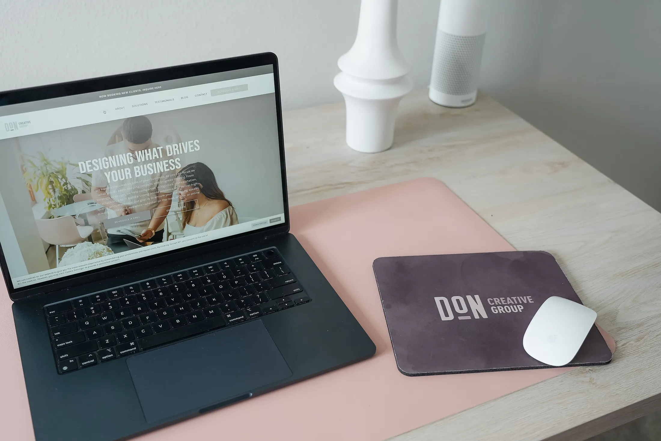 Laptop displaying a creative agency website on a modern desk with Don Creative Group branding