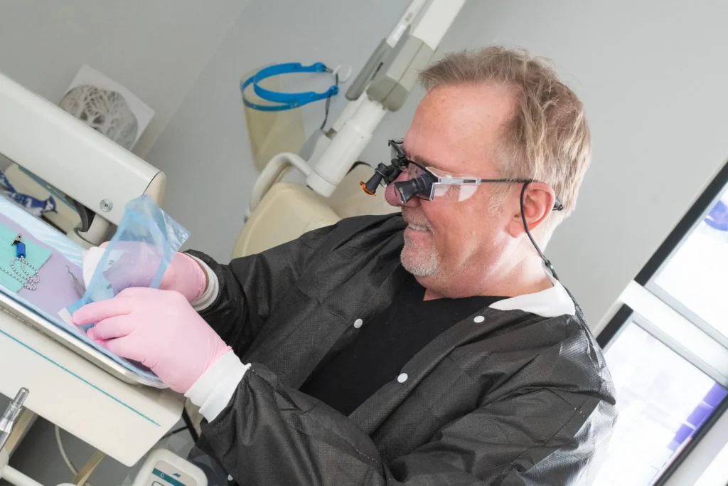 Pediatric Dentist Performing Dental Procedure with Precision Tools Pediatric dentist wearing magnification loupes and gloves while performing a detailed dental procedure in a modern dental office