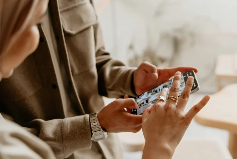 Two professionals reviewing visual content together on a smartphone during a collaborative discussion