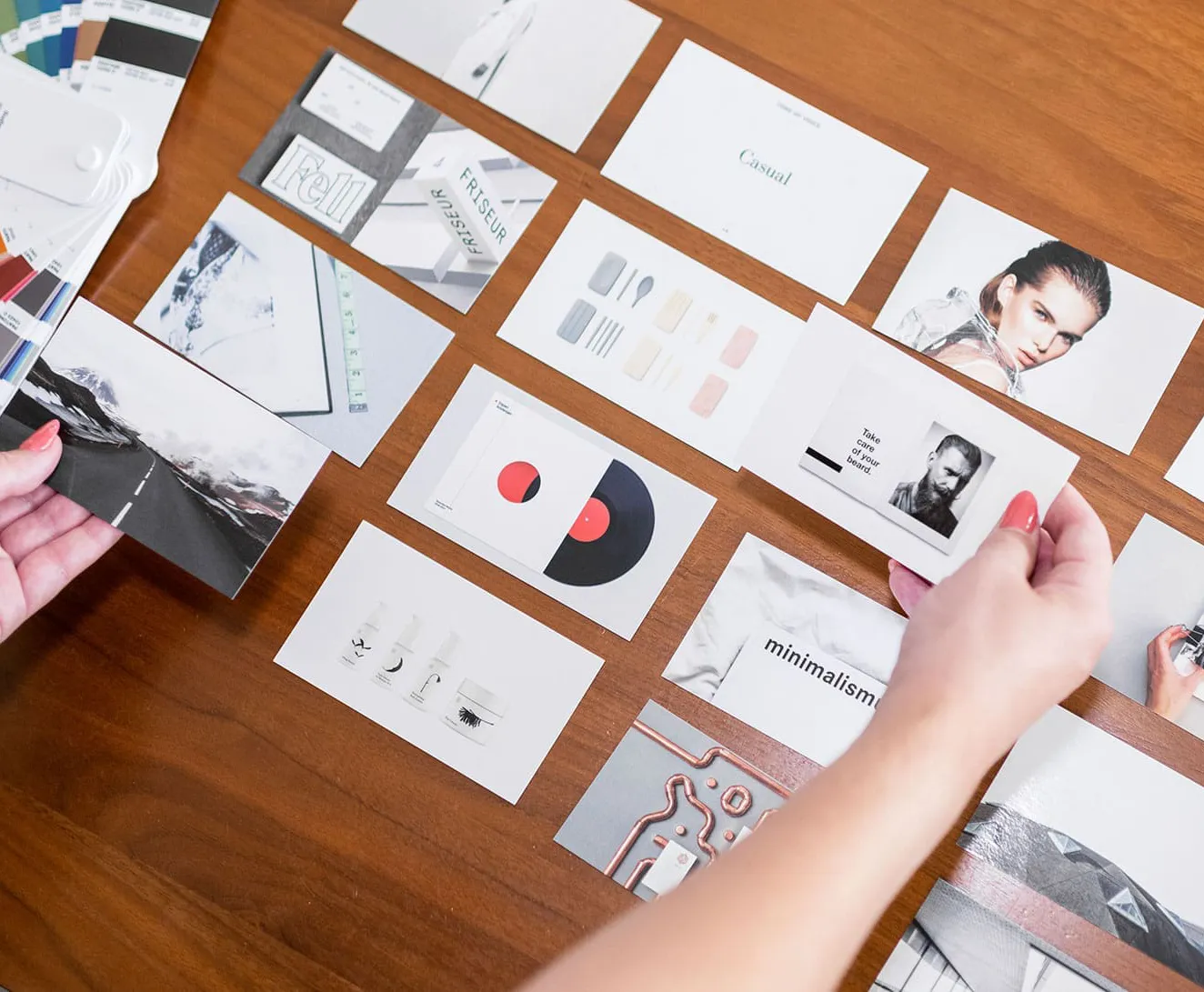 Brand identity concept development with mood board, Pantone color swatches, and visual branding layouts arranged on table.