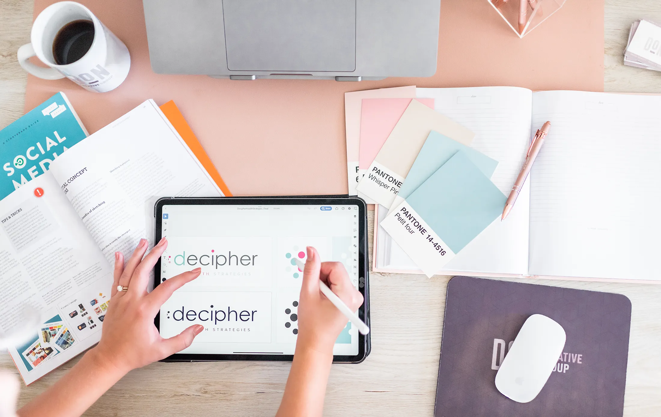 Brand identity designer creating logo concepts and selecting Pantone color palette for cohesive visual branding system.